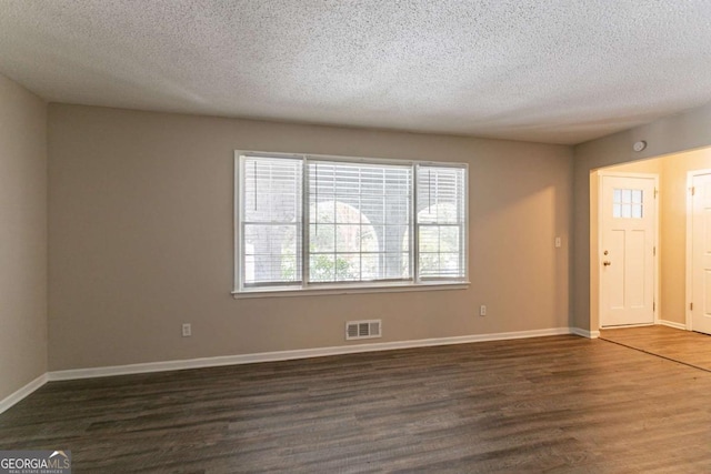 unfurnished room featuring dark hardwood / wood-style floors and a textured ceiling