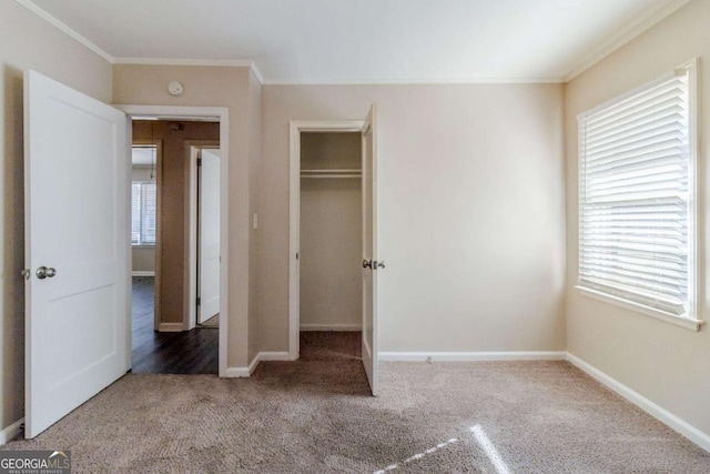 unfurnished bedroom with ornamental molding, carpet, and a closet