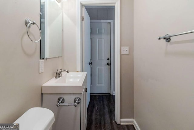 bathroom featuring vanity, hardwood / wood-style floors, and toilet