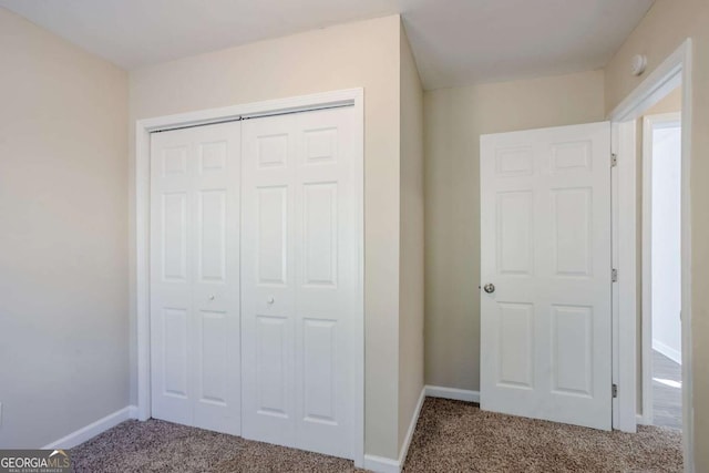 unfurnished bedroom with a closet and carpet flooring