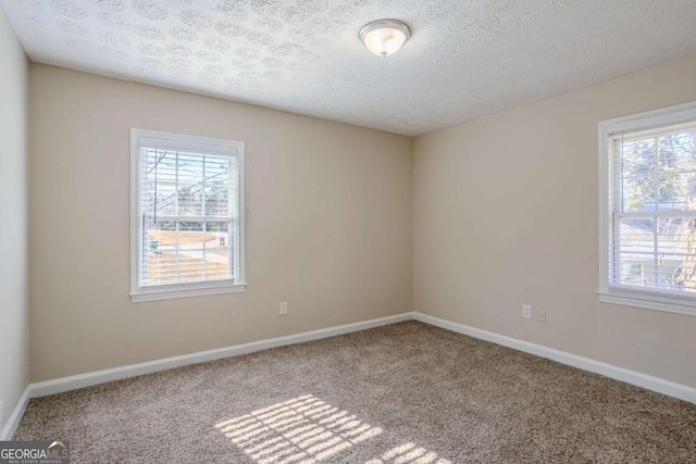 carpeted empty room featuring a textured ceiling