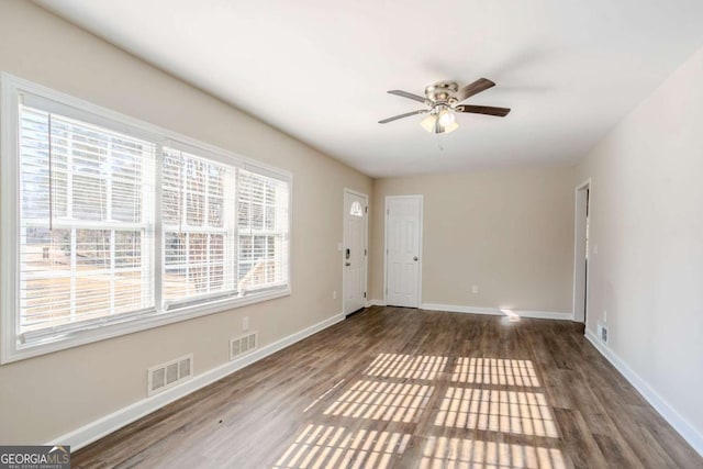 unfurnished room featuring dark wood-type flooring and ceiling fan