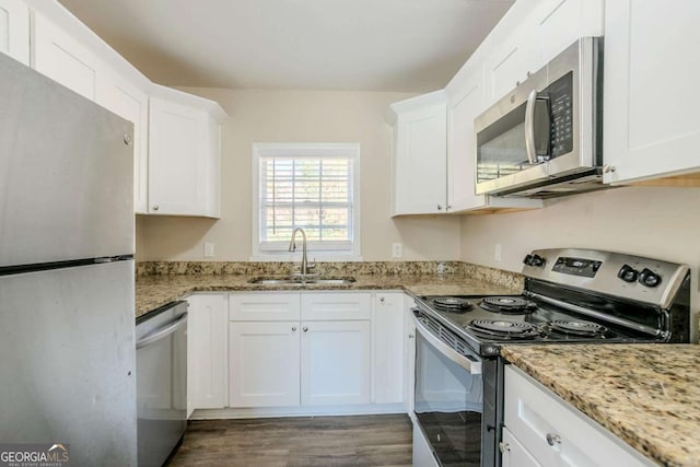 kitchen featuring white cabinetry, appliances with stainless steel finishes, sink, and light stone counters