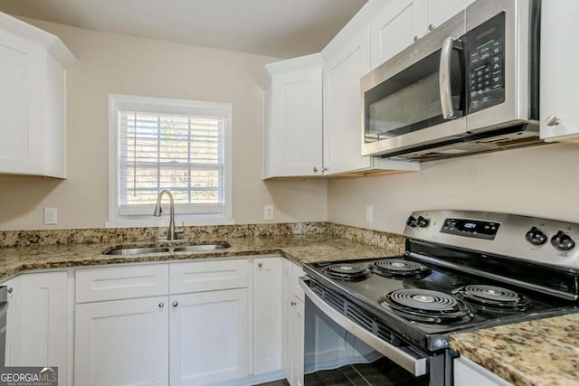 kitchen featuring white cabinetry, sink, light stone countertops, and appliances with stainless steel finishes