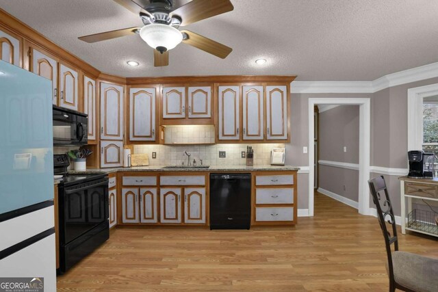 kitchen with sink, crown molding, black appliances, light stone countertops, and a textured ceiling