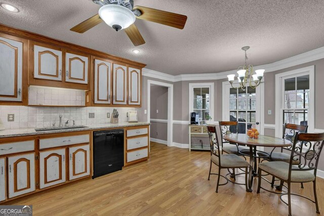 kitchen featuring decorative light fixtures, black dishwasher, sink, light hardwood / wood-style floors, and crown molding