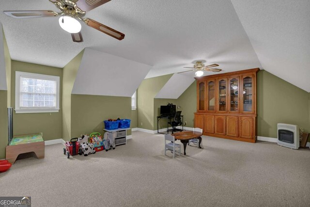 rec room featuring heating unit, light carpet, lofted ceiling, and a textured ceiling