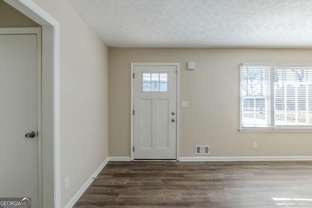 entrance foyer featuring dark wood-type flooring and a textured ceiling