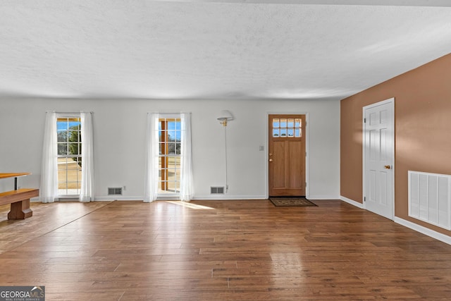 foyer featuring dark wood-type flooring and a textured ceiling