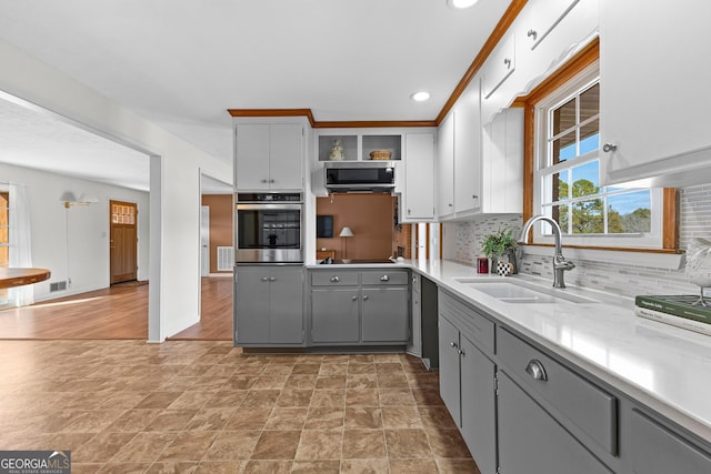 kitchen featuring tasteful backsplash, appliances with stainless steel finishes, sink, and gray cabinetry