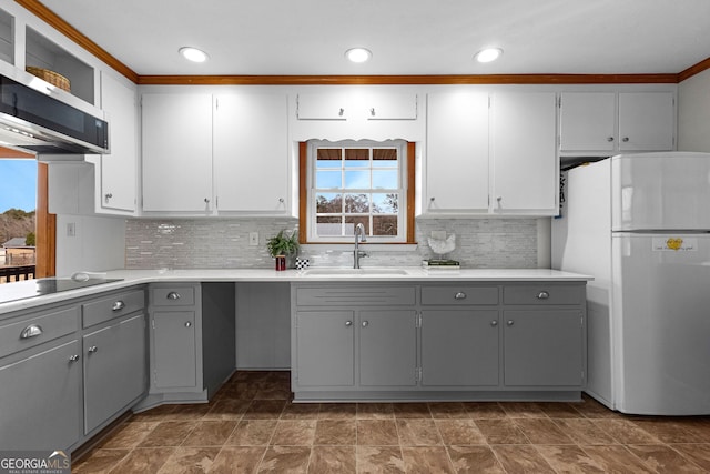 kitchen featuring gray cabinets, sink, ornamental molding, white fridge, and black electric cooktop