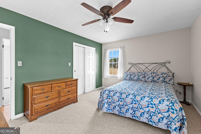 bedroom with light colored carpet, ceiling fan, and a closet