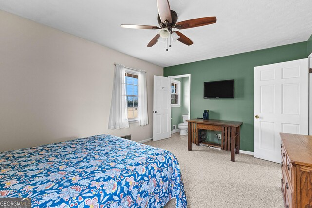 carpeted bedroom with ceiling fan and connected bathroom