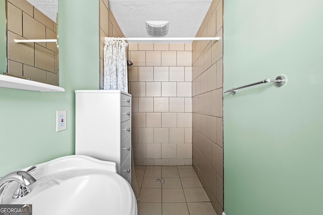 bathroom with sink, tile patterned floors, a textured ceiling, and a shower with shower curtain