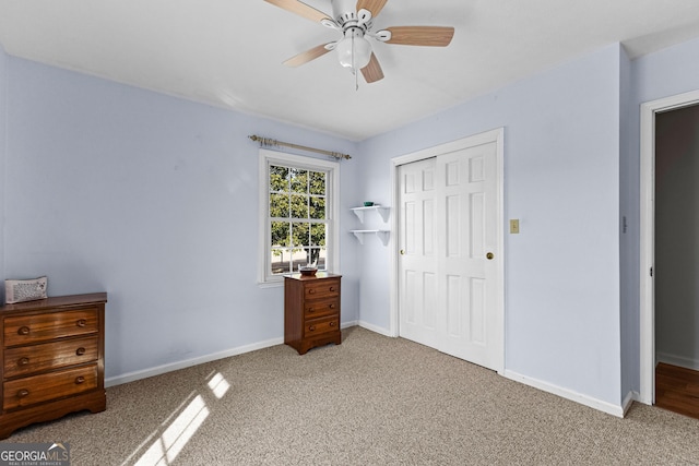 unfurnished bedroom featuring light carpet, a closet, and ceiling fan