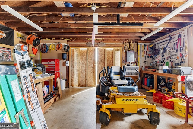 basement featuring electric panel and a workshop area