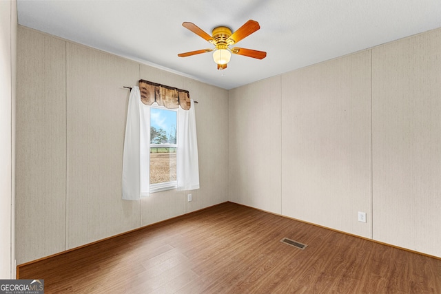 spare room featuring hardwood / wood-style floors and ceiling fan