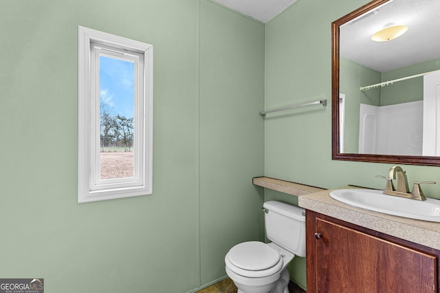 bathroom featuring vanity, a textured ceiling, and toilet