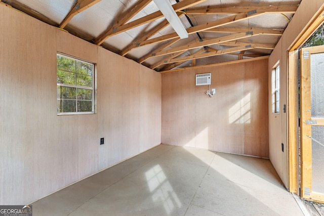 unfurnished room with vaulted ceiling with beams and a wall mounted air conditioner