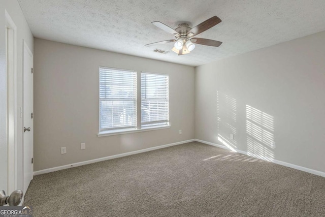 empty room with ceiling fan, carpet flooring, and a textured ceiling