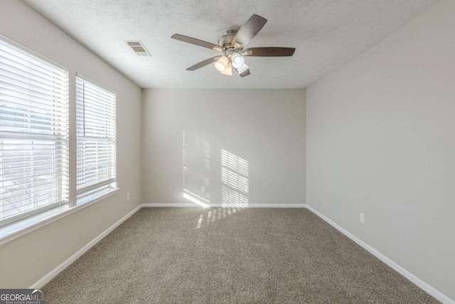 carpeted spare room with ceiling fan and a textured ceiling