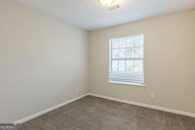 carpeted spare room with a textured ceiling