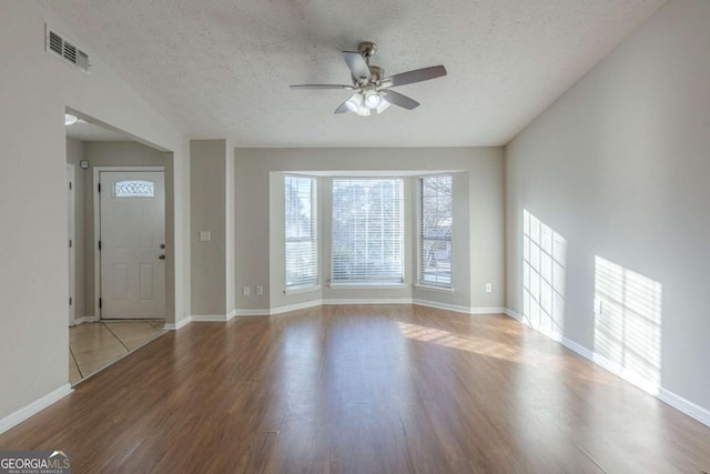 foyer entrance with hardwood / wood-style floors, a textured ceiling, and ceiling fan