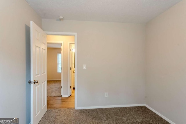 carpeted spare room with a textured ceiling