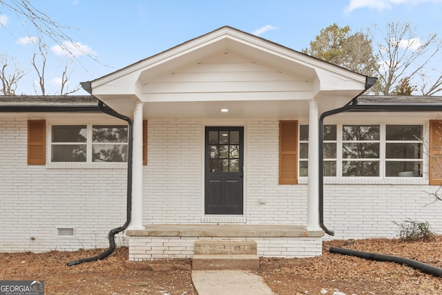 view of exterior entry with a porch