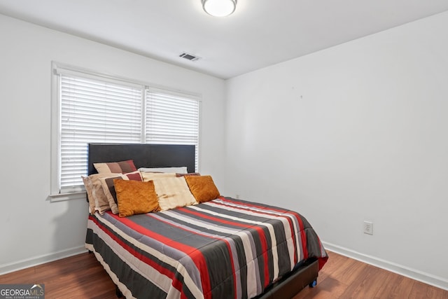 bedroom with dark wood-type flooring