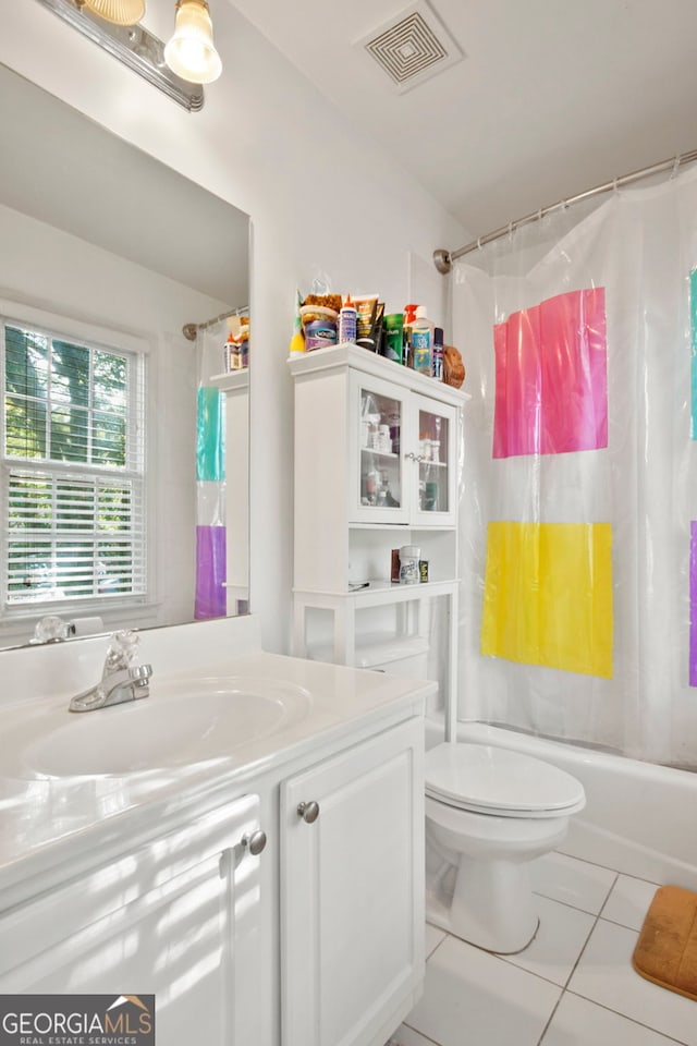 full bathroom featuring shower / bath combo with shower curtain, tile patterned floors, toilet, and vanity