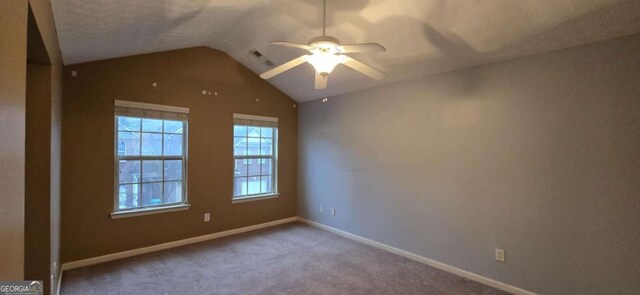 carpeted spare room featuring lofted ceiling and ceiling fan