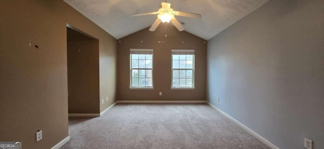 carpeted spare room with vaulted ceiling and ceiling fan