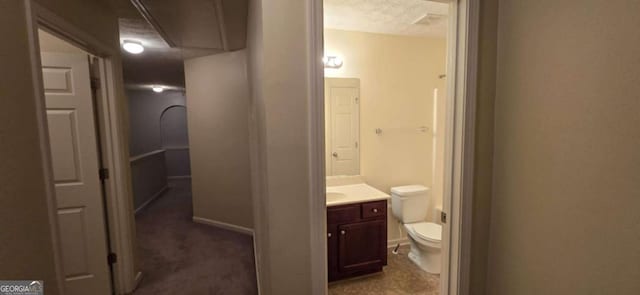 bathroom with vanity, a textured ceiling, and toilet