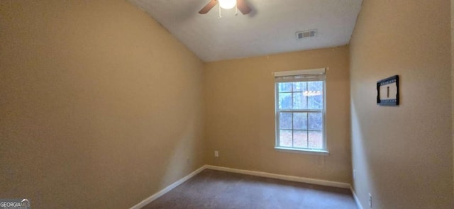 carpeted spare room featuring ceiling fan and lofted ceiling