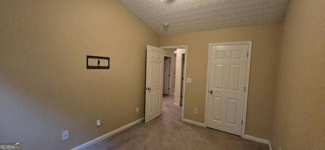 unfurnished bedroom with light carpet and a textured ceiling