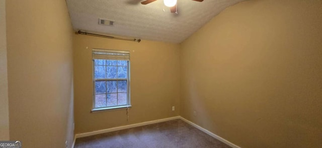 carpeted empty room featuring ceiling fan, plenty of natural light, lofted ceiling, and a textured ceiling