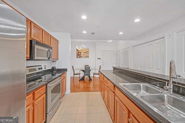 kitchen with sink, light tile patterned floors, and stainless steel appliances