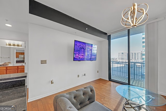 interior space with floor to ceiling windows, a chandelier, and light wood-type flooring