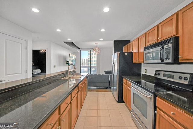 kitchen featuring light tile patterned flooring, stainless steel appliances, sink, and dark stone countertops