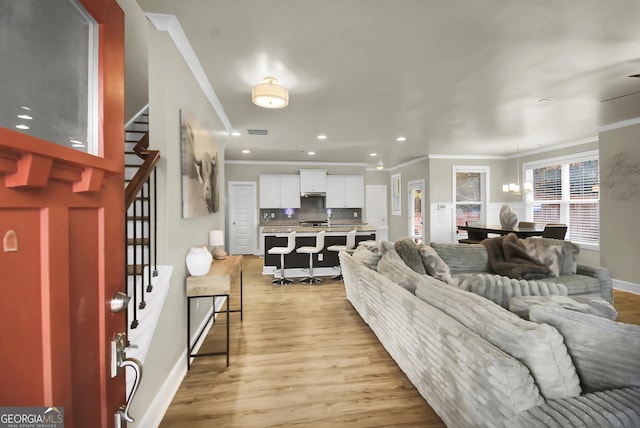 living room with crown molding and light wood-type flooring