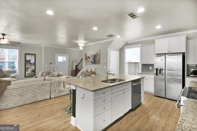 kitchen with appliances with stainless steel finishes, white cabinetry, sink, a kitchen island with sink, and ceiling fan