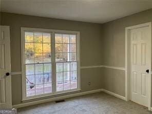 interior space featuring multiple windows and light carpet