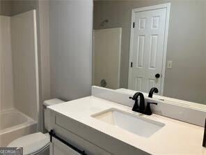 full bathroom with bathing tub / shower combination, vanity, and toilet