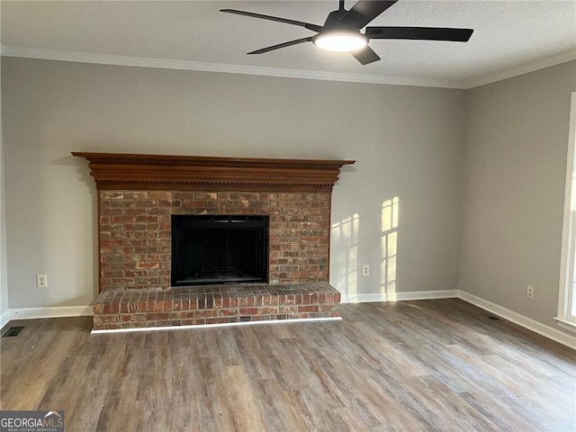 unfurnished living room with a brick fireplace, crown molding, ceiling fan, and hardwood / wood-style flooring