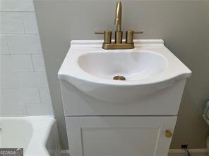 interior details featuring vanity and a tub to relax in