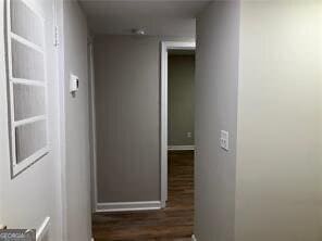 hallway with dark hardwood / wood-style flooring