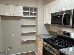 kitchen featuring white cabinetry, light stone countertops, and appliances with stainless steel finishes