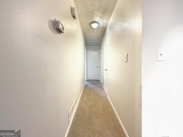 corridor featuring a textured ceiling