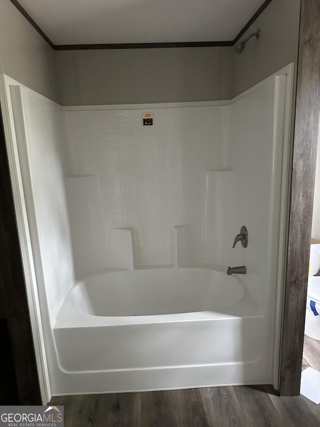 bathroom featuring wood-type flooring and washtub / shower combination